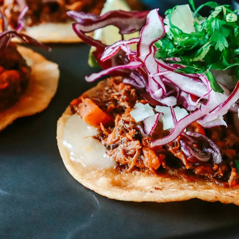 Tinga de pollo la airfryer: pui mărunțit în sos afumat de roșii și chipotle, pe tostadas crocante